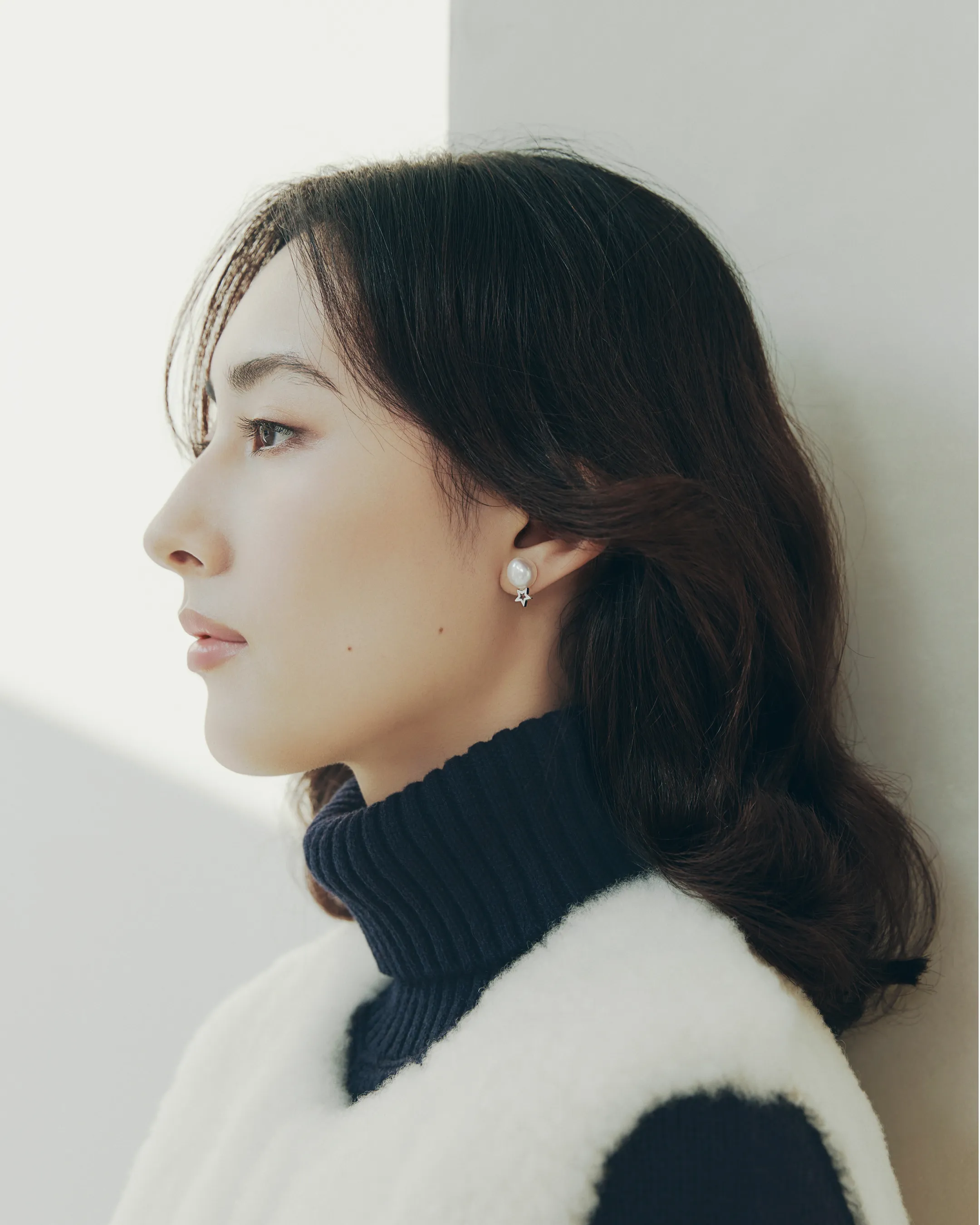 モデルに近づくことで、耳に付けられたプティ コリエ ピアス「トゥインクル プティ」がはっきりと写っている様子