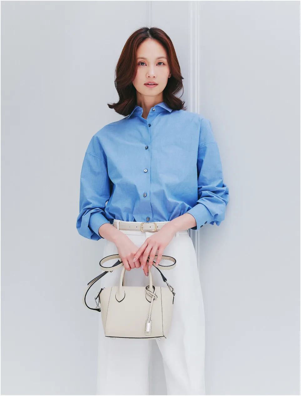 モデルによるミニショルダーバッグ、手持ちスタイル。