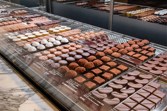 和光アネックス1階ケーキ＆チョコレートショップの棚にて、数え切れないくらいのチョコレートが陳列している