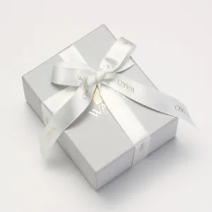 グレーのシンプルな箱に白色のリボンが巻かれている